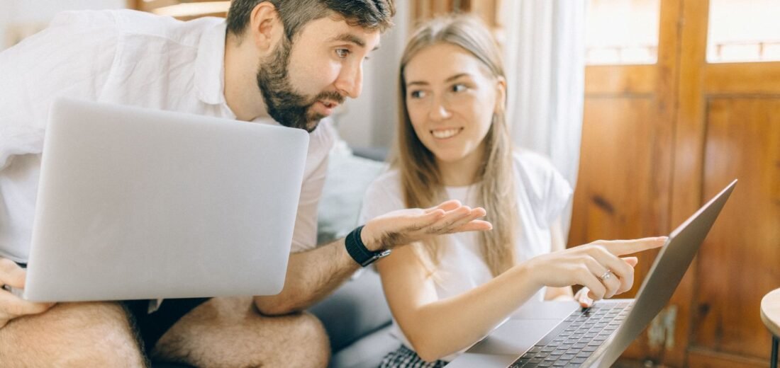 Couple comparant les offres sur un ordinateur pour trouver le fournisseur d'électricité le moins cher en Wallonie